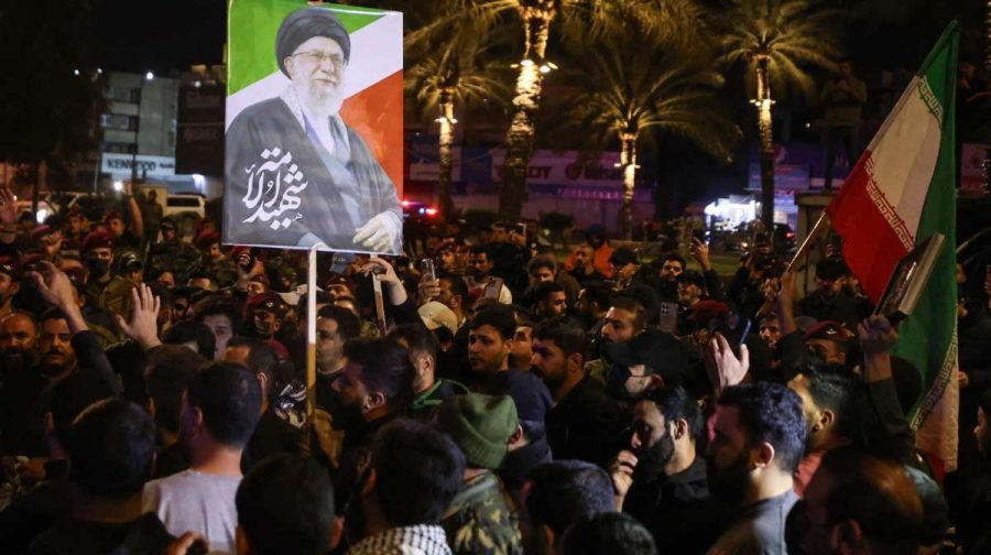 A photo of slain Iranian supreme leader Ayatollah Ali Khamenei is held as mourners attend a funeral for members of Iraq's Hashed al-Shaabi, who were killed in an attack in al-Qaim province near the Syria border the previous evening, in Baghdad on March 17, 2026. (Photo by AHMAD AL-RUBAYE / AFP) /