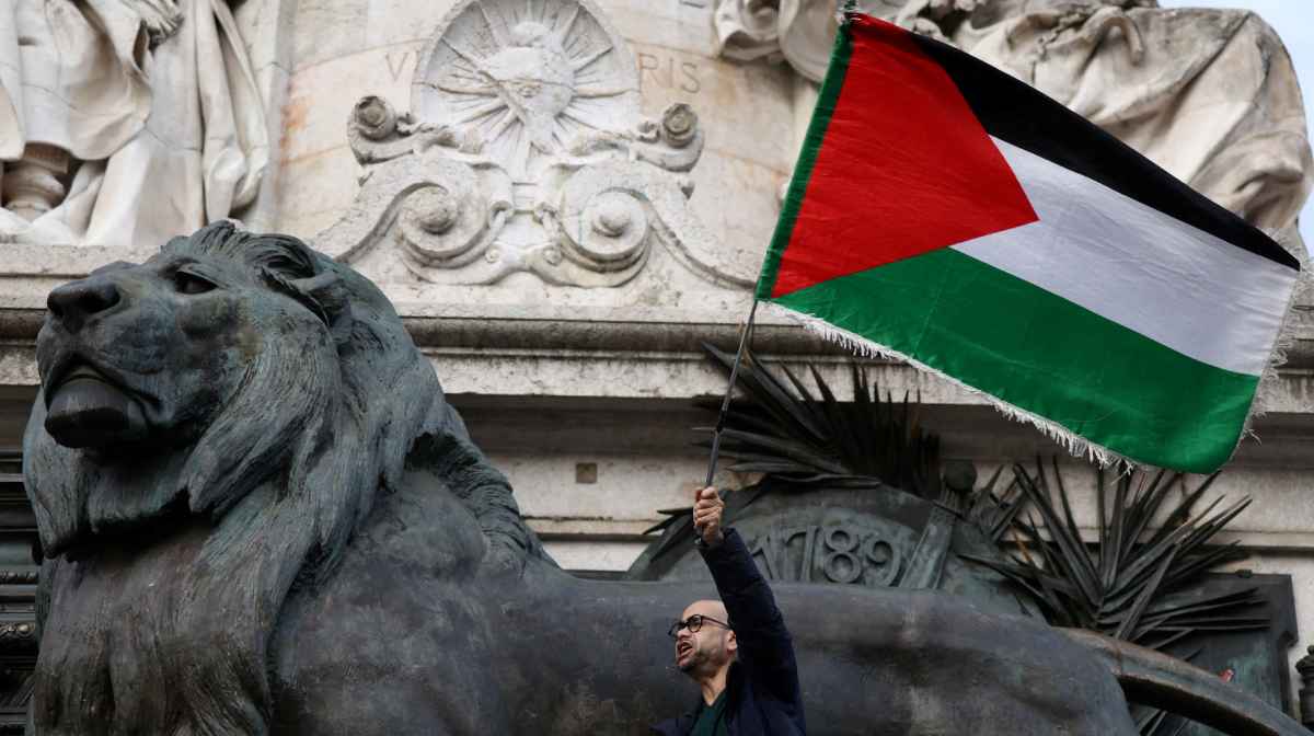 A protester holds a Palestinian flag during a protest to condemn the Israeli forces' interception of the vessels of the Global Sumud Flotilla aiming to reach Gaza and break Israel's naval blockade and for the release of the crews, and to protest against Israel's operations in the Gaza Strip, amid the ongoing Israel-Hamas conflict, at the Place de la Republique in Paris, France, October 2, 2025. REUTERS/Tom Nicholson      TPX IMAGES OF THE DAY     