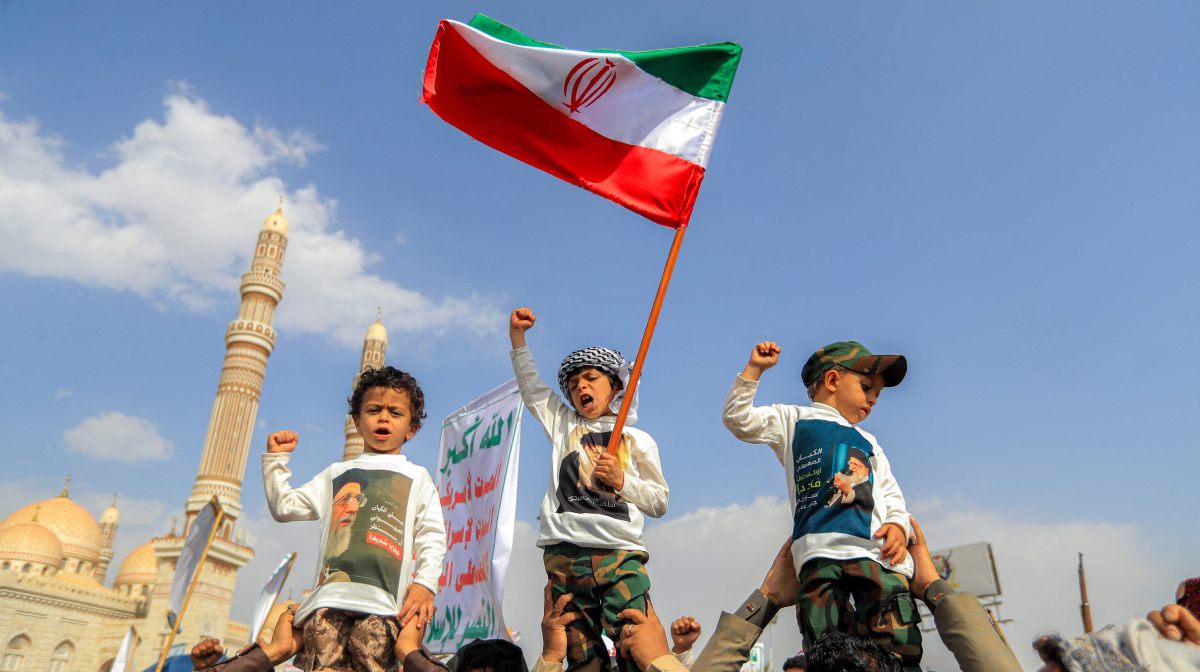 TOPSHOT - A boy waves an Iranian flag while chanting slogans with others during a rally by supporters of Yemen's Huthis in solidarity with Iran and Palestinians in the Gaza Strip while condemning Israel, in the Huthi-held capital Sanaa on June 20, 2025. (Photo by Mohammed HUWAIS / AFP)