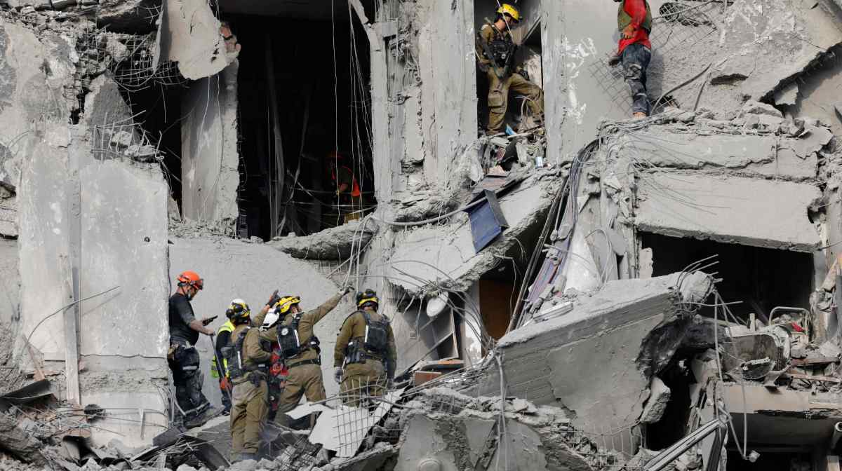TOPSHOT - Emergency workers check the damage caused to a building from an Iranian missile strike in Beersheba in southern Israel on June 24, 2025. Israeli emergency services said on June 24 three people were killed and two wounded in an Iranian missile strike in southern Israel, shortly before a staggered ceasefire announced by US President Donald Trump was meant to enter force. (Photo by John Wessels / AFP)