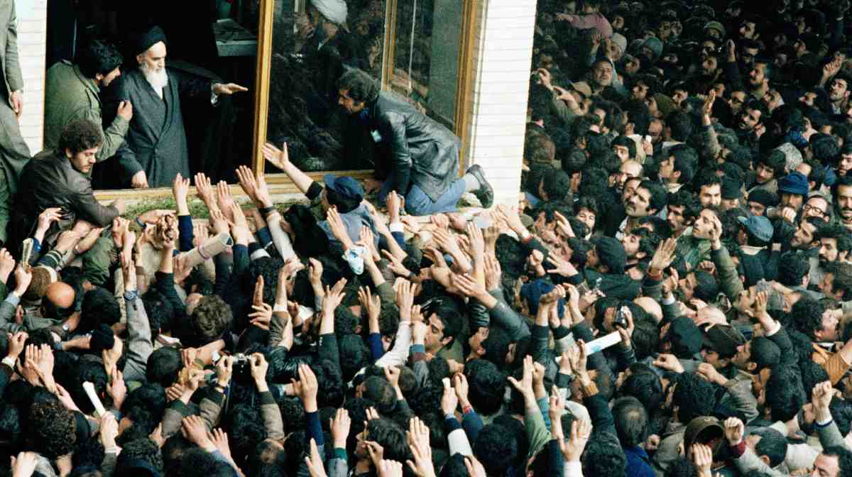 FILE - People jam into the schoolyard in Tehran to see the Ayatollah Ruhollah Khomeini, who blesses the crowd, on Feb. 4, 1979. (AP Photo/Michel Lipchitz, File)