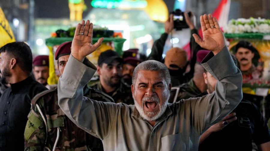 A mourner reacts while marching ahead of the paramilitary group Hezbollah Brigades (Kataeb Hezbollah), who were killed in a strike on their site in Baghdad's al-Jadriya area, during their funeral at the shrine of Imam Ali in Iraq's central holy city of Najaf on March 14, 2026. (Photo by Qassem al-KAABI / AFP)