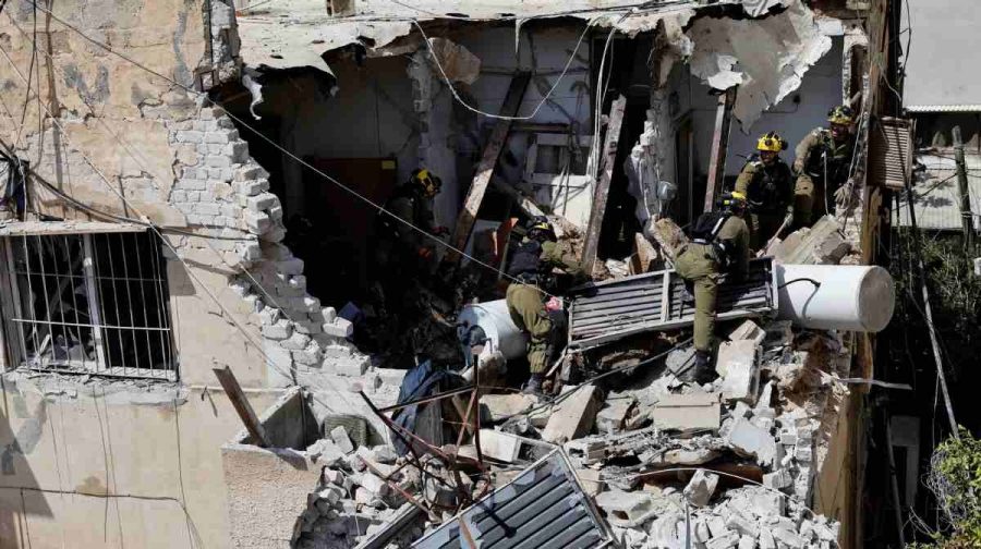 Israeli soldiers inspect the site of a damaged building following barrages of Iranian missiles, amid the U.S.-Israeli conflict with Iran, in Tel Aviv, Israel, March 22, 2026. REUTERS/Amir Cohen