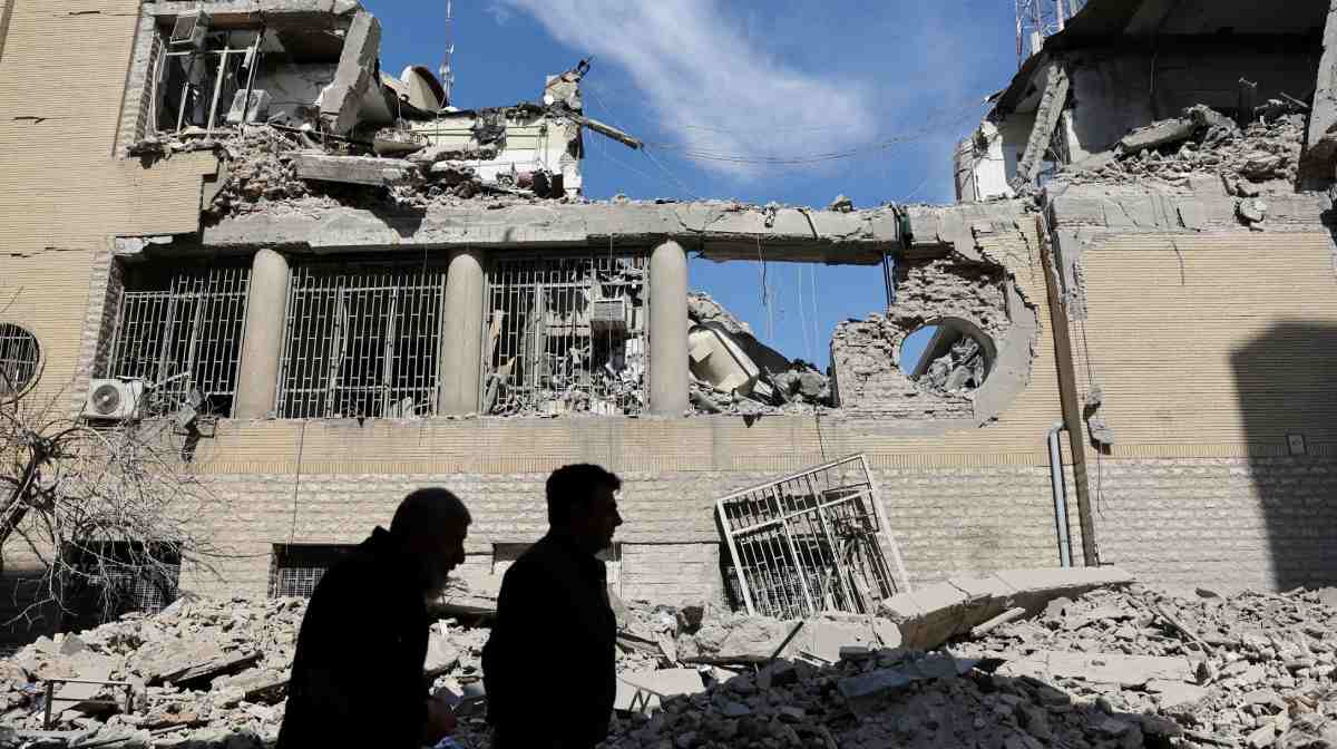 People walk past damaged buildings following a strike on a police station, amid the U.S.-Israeli conflict with Iran, in Tehran, Iran, March 4, 2026. Majid Asgaripour/WANA (West Asia News Agency) via REUTERS ATTENTION EDITORS - THIS PICTURE WAS PROVIDED BY A THIRD PARTY     TPX IMAGES OF THE DAY     