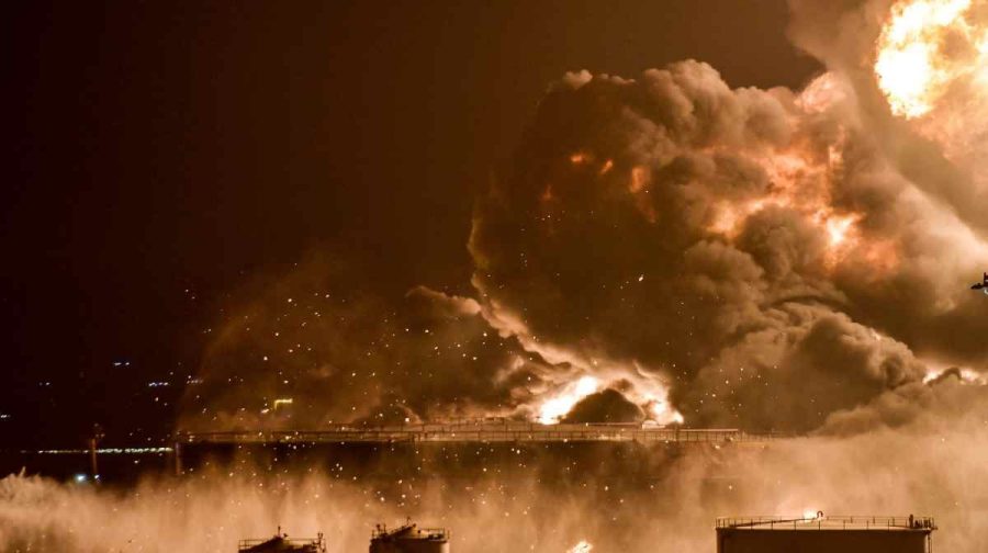 Water is sprayed by fire brigades toward the smoke and flames rising from a Saudi Aramco oil facility in Saudi Arabia's Red Sea coastal city of Jeddah, on March 25, 2022, following a reported Yemeni rebels attack. - Yemeni rebels said they attacked a Saudi Aramco oil facility in Jeddah as part of a wave of drone and missile assaults today as a huge cloud of smoke was seen near the Formula One venue in the city. (Photo by AFP)