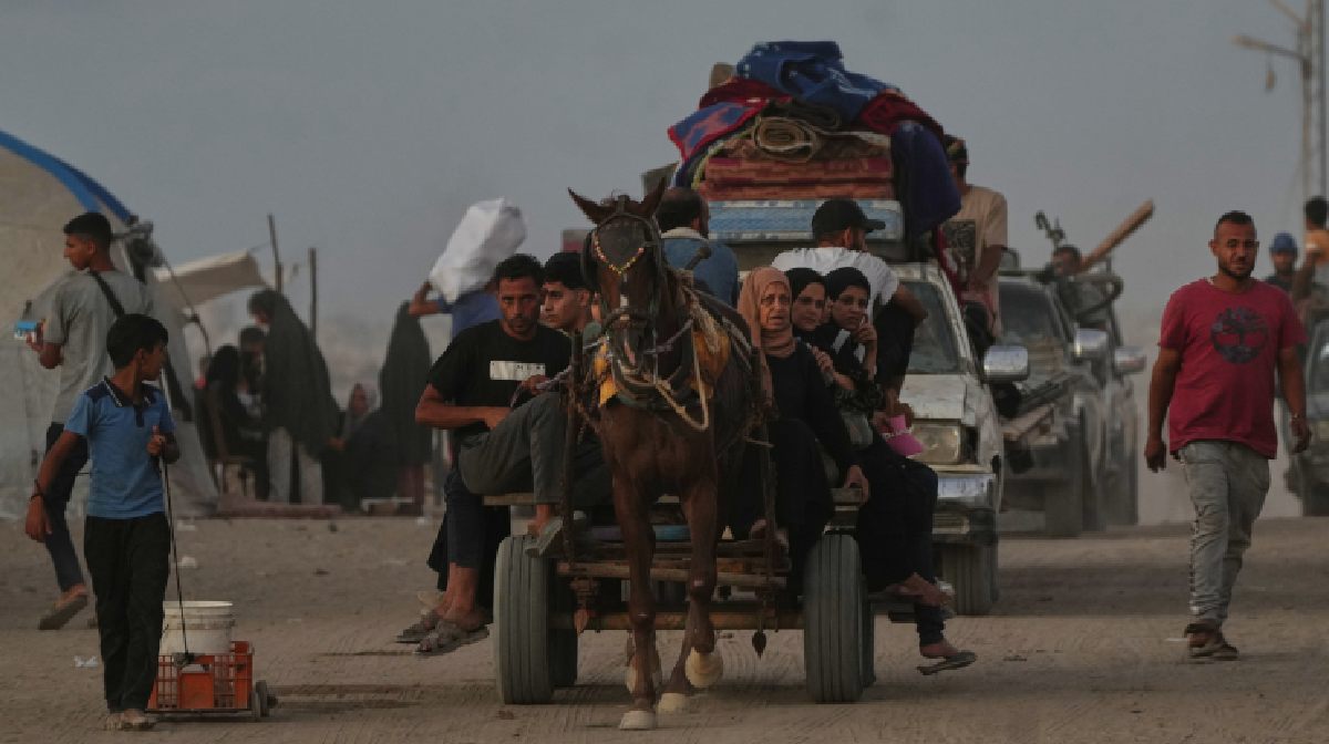 Displaced Palestinians flee northern Gaza carrying their belongings along the coastal road near Wadi Gaza (AP Photo/Abdel Kareem Hana)