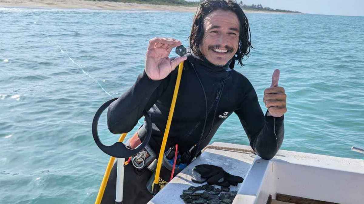 In this undated photo provided by shipwreck salvage company 1715 Fleet- Queens Jewels, LLC, diver Levin Shavers shows coins uncovered from a Spanish shipwreck off the Atlantic coast of Florida, 2025. (1715 Fleet - Queens Jewels, LLC via AP)
