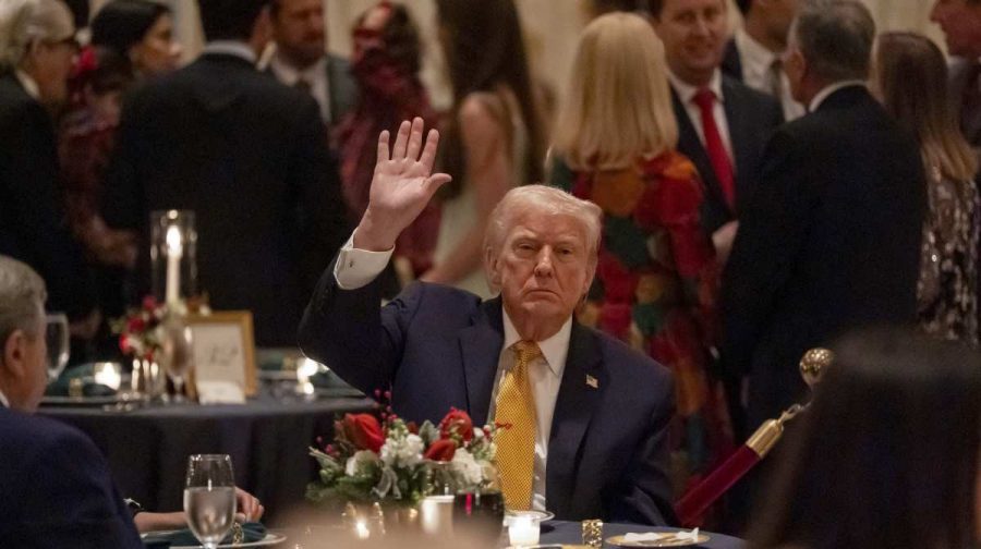 President Donald Trump waves at Christmas Eve dinner at his Mar-a-Lago club, Wednesday, Dec. 24, 2025, in Palm Beach, Fla. (AP Photo/Alex Brandon)