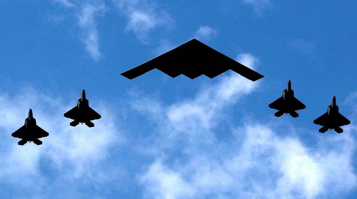 A U.S. Air Force B-2 Spirit Stealth Bomber (C) is flanked by four F-22 Raptor fighter planes during a flyover of military aircraft down the Hudson River and New York Harbor past York City, and New Jersey, U.S. July 4, 2020. REUTERS/Mike Segar REFILE - CORRECTING AIRCRAFT FROM "U.S. MARINE CORPS F-35 FIGHTERS" TO "F-22 RAPTOR FIGHTER PLANES".