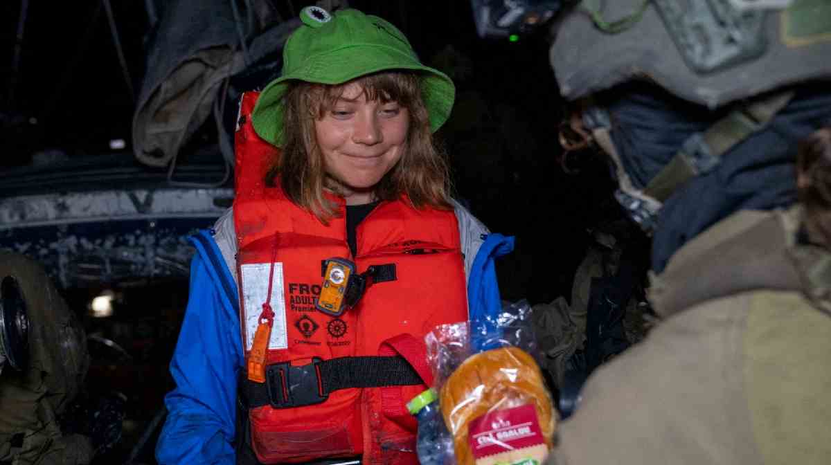 An Israeli solider passes a bun to Greta Thunberg onboard the Gaza-bound British-flagged yacht "Madleen" after Israeli forces boarded the charity vessel as it attempted to reach the Gaza Strip in defiance of an Israeli naval blockade, in this still image released on June 9, 2025. Israel Foreign Ministry via X/Handout via REUTERS 