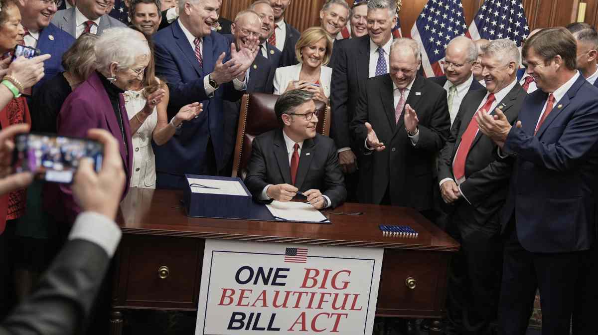 Speaker of the House Mike Johnson, R-La., center, surrounded by fellow Republicans, signs President Donald Trump's signature bill of tax breaks and spending cuts, Thursday, July 3, 2025, at the Capitol in Washington. (AP Photo/Mariam Zuhaib)
