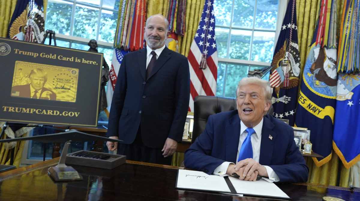 President Donald Trump speaks as Commerce Secretary Howard Lutnick listens alongside a poster of the Trump Gold Card in the Oval Office of the White House, Friday, Sept. 19, 2025, in Washington. (AP Photo/Alex Brandon)
