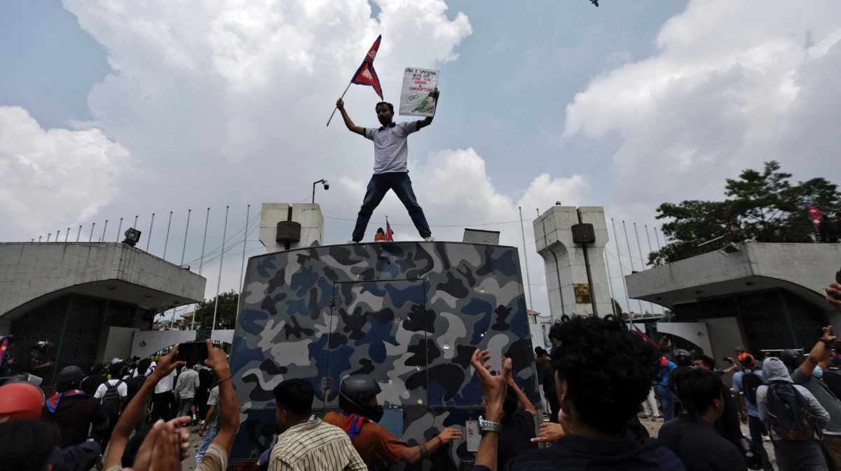 A demonstrator waves a flag as he stands atop a vehicle near the entrance of the Parliament during a protest against corruption and government s decision to block several social media platforms, in Kathmandu, Nepal September 8, 2025. REUTERS/Navesh Chitrakar     TPX IMAGES OF THE DAY     