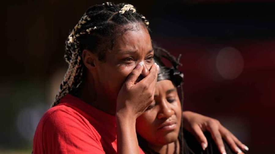People grieve as they comfort each other outside the scene of a mass shooting, Sunday, April 19, 2026, in Shreveport, La. (AP Photo/Gerald Herbert)