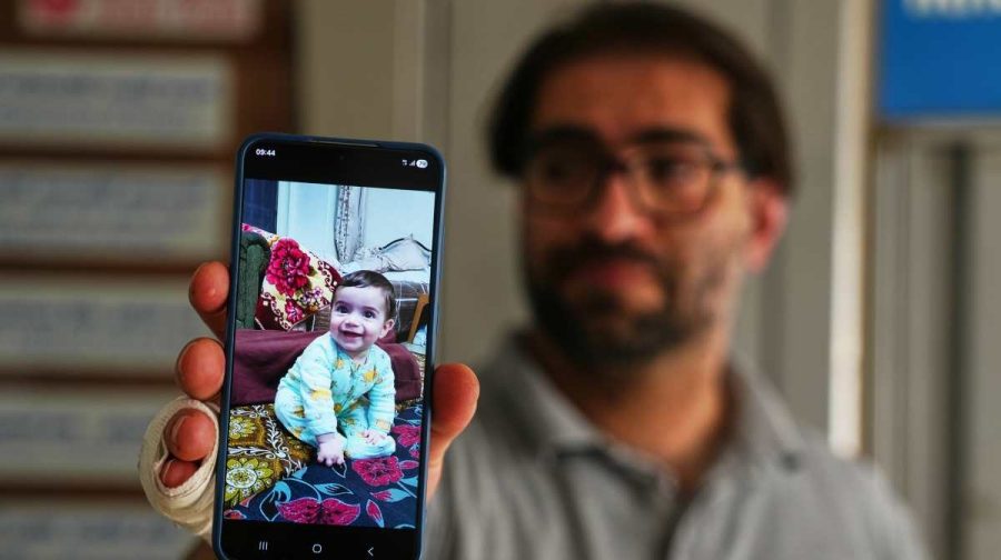 Fahd Abu Haikal, 41 displays a mobile photo of his seven month old Palestinian baby boy Sam, who was killed on Friday (AP Photo/Mahmoud Illean)