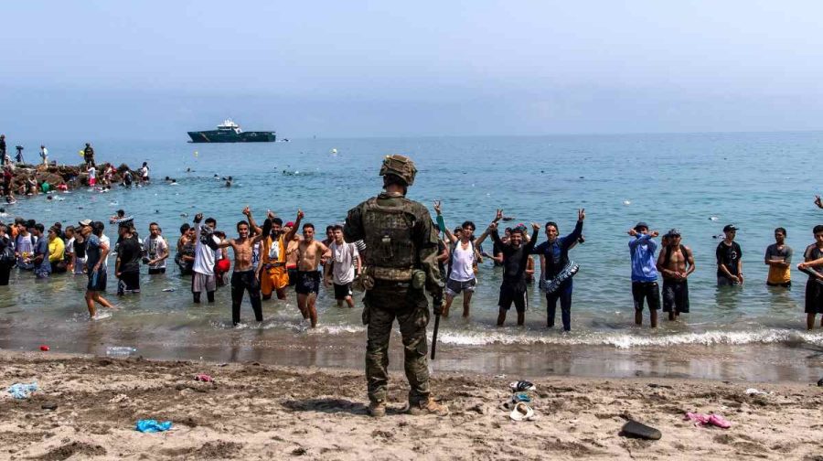 Spanish army soldiers block access to the beach for people crossing from Morocco into the Spanish enclave of Ceuta, Friday, July 31, 2026. (AP Photo/Antonio Sempere)