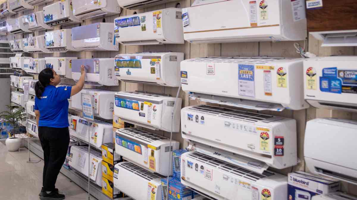 An employee cleans an air conditioner displayed inside an electronics store, on a hot summer day in New Delhi, India, April 9, 2025. REUTERS/Adnan Abidi