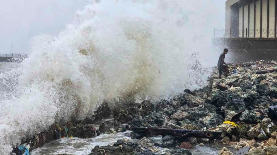 Ramanathapuram: A man stands on rocks as waves crash against the seaside during rough sea conditions triggered by Cyclone Ditwah, in Ramanathapuram, Tamil Nadu, Friday, Nov. 28, 2025. (PTI Photo)(PTI11_28_2025_000336A)