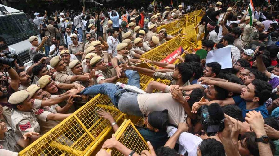Supporters of the Cockroach Janta Party scuffle with police as they attempt to march toward India's Parliament, demanding the resignation of the education minister, in New Delhi, Monday, July 20, 2026. (AP Photo/Vipin)