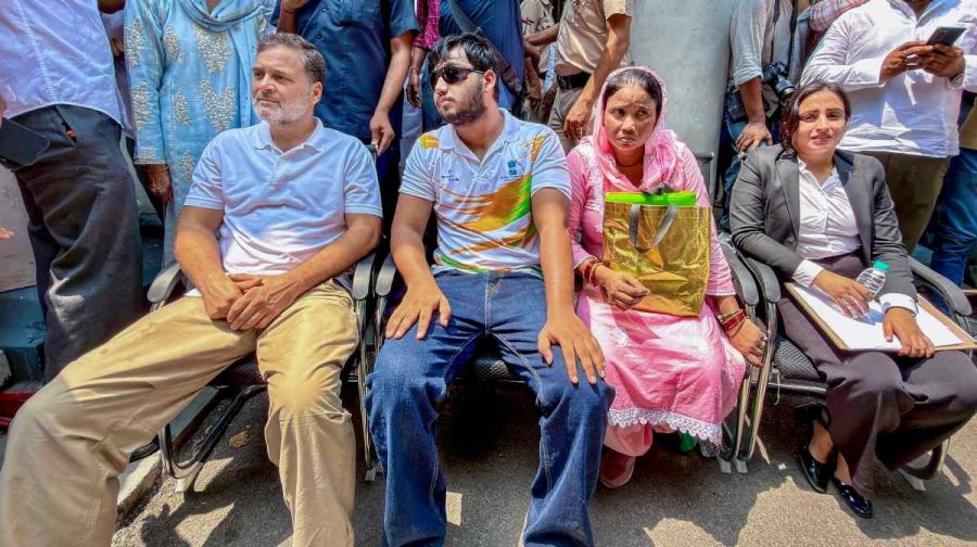 In this image received on Aug. 21, 2026, Leader of Opposition in the Lok Sabha Rahul Gandhi, left, sits on dharna at Parliament Street police station demanding registration of FIR over pellet injuries during Jul 20 protest, in New Delhi. 