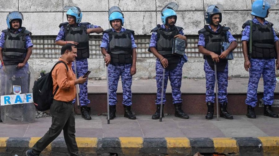 Rapid Action Force (RAF) personnel stand guard at Connaught Place in New Delhi on July 23, 2026, amid an ongoing protest at Jantar Mantar demanding the resignation of India's Education Minister Dharmendra Pradhan over alleged NEET examination irregularities. Indian Prime Minister Narendra Modi vowed "stringent punishment" on July 23 for anyone involved in leaking exam papers, a scandal that has sparked protests challenging his administration. (Photo by Arun SANKAR / AFP)