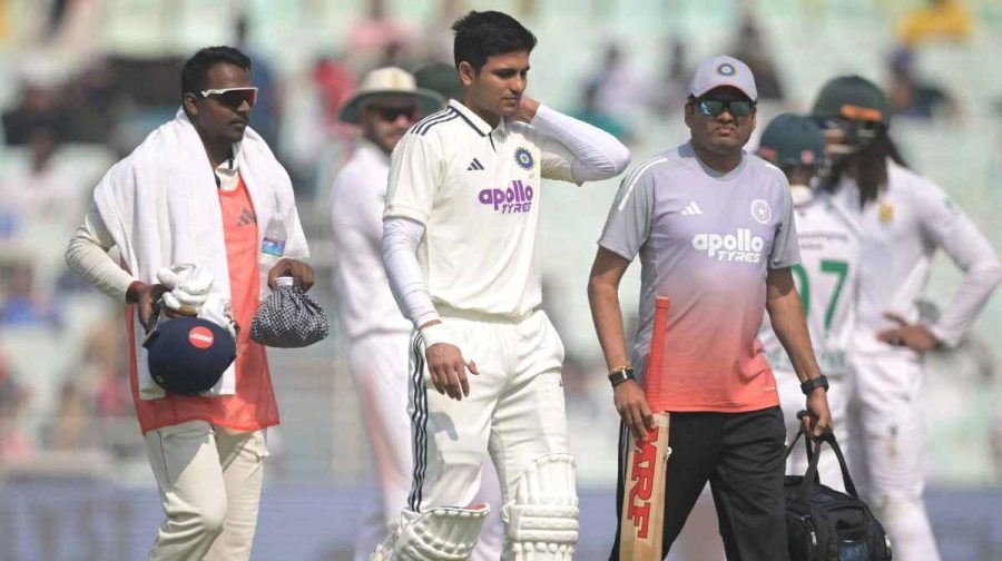 India's captain Shubman Gill (C) walks back to the pavilion after his injury during the second day of the first Test cricket match between India and South Africa at the Eden Gardens in Kolkata on November 15, 2025. (Photo by DIBYANGSHU SARKAR / AFP) / -- IMAGE RESTRICTED TO EDITORIAL USE - STRICTLY NO COMMERCIAL USE --