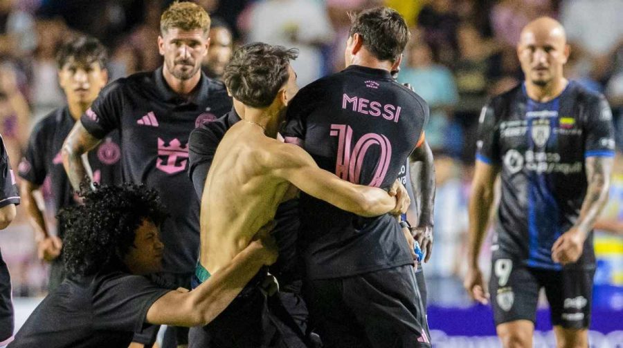 A fan who got onto the field grabs Inter Miami's Lionel Messi at the end of an international friendly soccer match against Ecuador's Independiente del Valle in Bayamon, Puerto Rico, Thursday, Feb. 26, 2026. (AP Photo/Alejandro Granadillo)