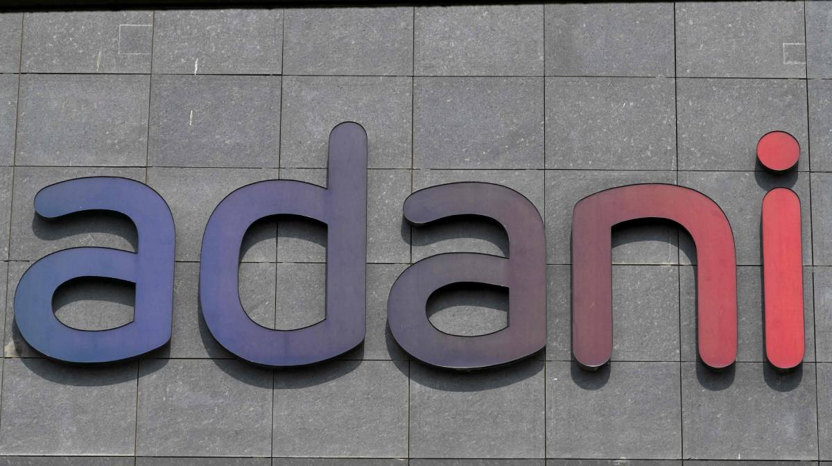 A signage of Indian conglomerate Adani is seen on a corporate building in Mumbai on February 2, 2023. - Trading was suspended on February 2 in the shares of five more firms in tycoon Gautam Adani's beleaguered business empire after their prices plunged in opening trade. (Photo by INDRANIL MUKHERJEE / AFP)