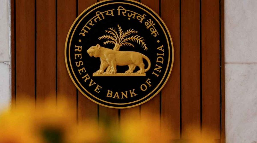 FILE PHOTO: A man speaks on his phone as he walks past the Reserve Bank of India (RBI) logo inside its headquarters in Mumbai, India, February 7, 2025. REUTERS/Francis Mascarenhas//File Photo