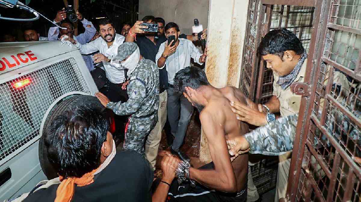 The accused, allegedly involved in a case of rape, and blackmail of college students, is escorted by police after being produced before the district court, in Bhopal on Monday. (ANI Photo)