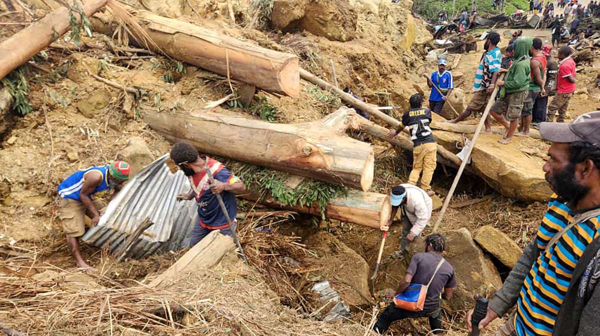 This handout photo taken and received on May 27, 2024 from the International Organization for Migration shows locals digging at the site of a landslide at Mulitaka village in the region of Maip Mulitaka, in Enga Province, Papua New Guinea. More than 2,000 people have been buried in a Papua New Guinea landslide that destroyed a remote highland village, the government warned May 27 as it called for international help in the rescue effort. (Photo by Mohamud Omer / International Organization for Migration / AFP) / RESTRICTED TO EDITORIAL USE - MANDATORY CREDIT "AFP PHOTO / INTERNATIONAL ORGANIZATION FOR MIGRATION / MOHAMUD OMER - NO MARKETING NO ADVERTISING CAMPAIGNS - DISTRIBUTED AS A SERVICE TO CLIENTS - NO ARCHIVE
