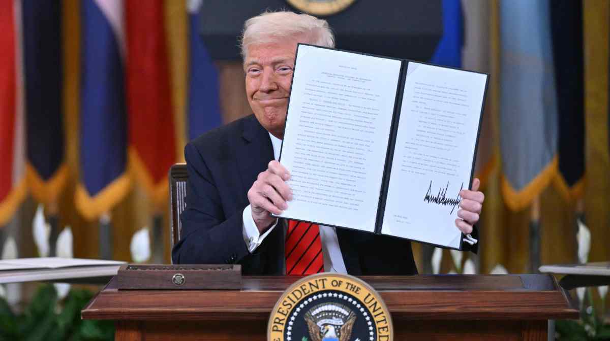 TOPSHOT - US President Donald Trump holds up an executive order after signing it during an education event in the East Room of the White house in Washington, DC, March 20, 2025. President Donald Trump signed an order aimed at shutting down the Department of Education, a decades-long goal on the US right that objects to federal involvement in school systems run by individual states. By law, the Education Department -- created in 1979 -- cannot be shuttered without the approval of Congress, and Republicans do not have the votes to push that through. (Photo by ROBERTO SCHMIDT / AFP)