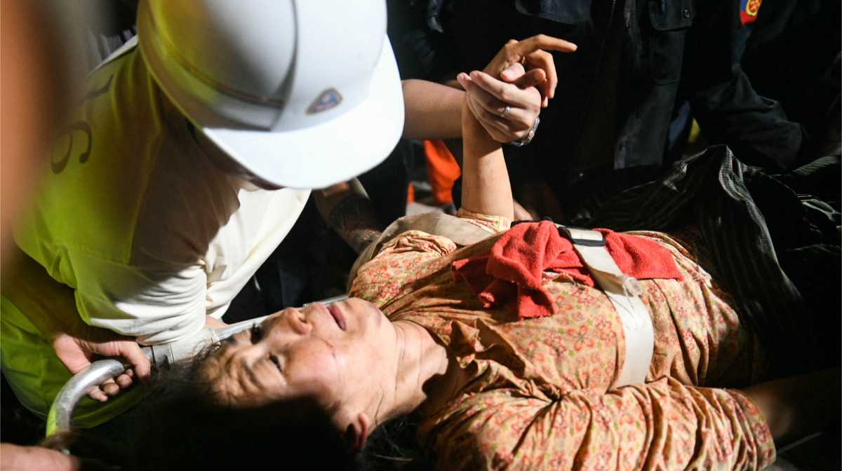 Ye Aung accompanies his wife Phyu Lay Khaing on their way to the hospital after she was rescued from the rubble of the collapsed Sky Villa Condo apartment building in Mandalay on March 29, 2025, a day after an earthquake struck central Myanmar. The death toll from a huge earthquake that hit Myanmar and Thailand passed 1,000 on March 29, as rescuers dug through the rubble of collapsed buildings in a desperate search for survivors. (Photo by Sai Aung MAIN / AFP)