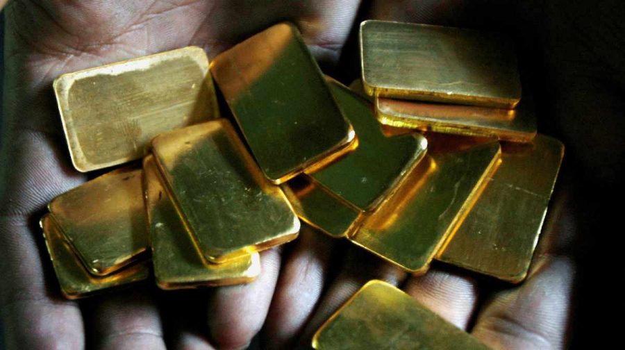 FILE PHOTO: A worker shows gold biscuits at a precious metals refinery in Mumbai, India March 3, 2008.   REUTERS/Arko Datta/File Photo