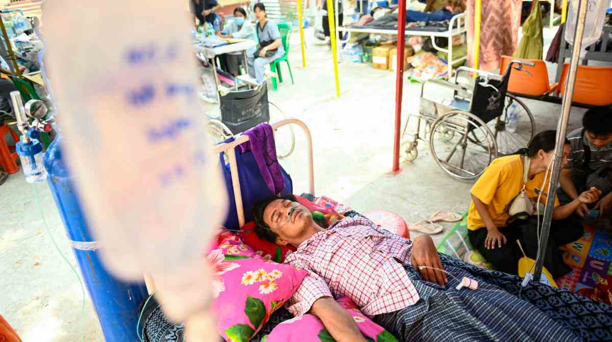 Survivor Tin Maung Htwe lies on a bed in the compound of a hospital as he receives treatment a day after his extraction from the ruins of a hotel in Sagaing on April 3, 2025, following the March 28 earthquake. (Photo by Sai Aung MAIN / AFP)