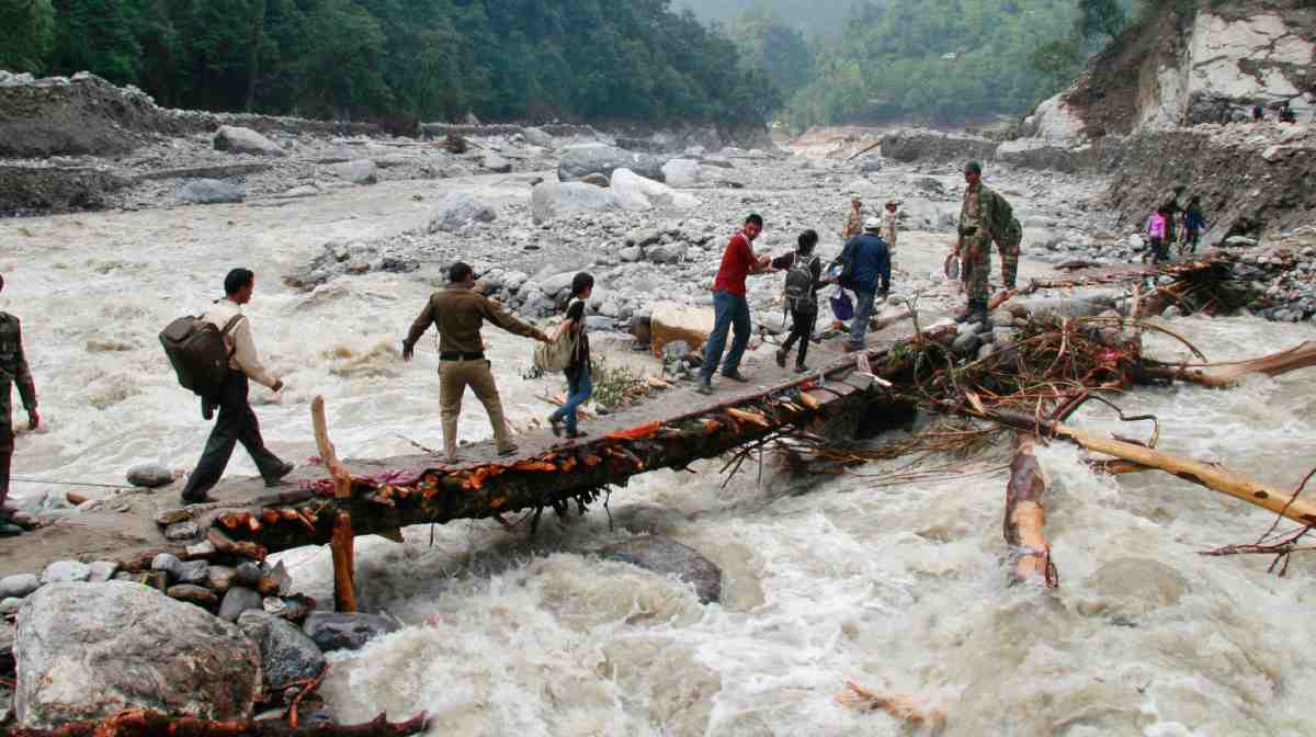 Indian army personnel help stranded people cross a flooded river after heavy rains in the Himalayan state of Uttarakhand June 23, 2013. Flash floods and landslides unleashed by early monsoon rains have killed at least 560 people in Uttarakhand and left tens of thousands missing, officials said on Saturday, with the death toll expected to rise significantly. Picture taken June 23, 2013. REUTERS/Stringer (INDIA - Tags: DISASTER ENVIRONMENT MILITARY TPX IMAGES OF THE DAY)