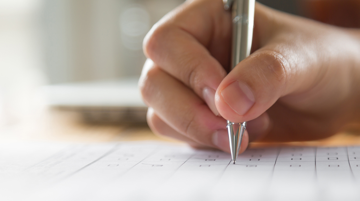 Hand with pen over application form