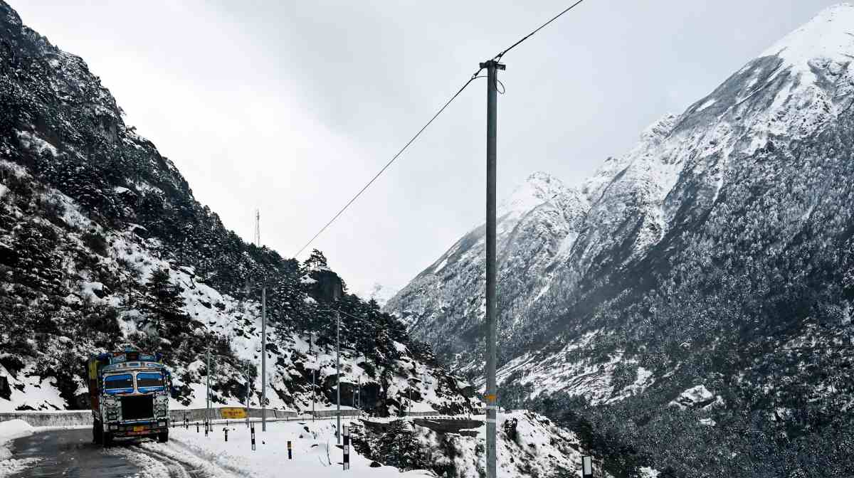 This picture taken on April 5, 2023 shows a truck on a snow laden highway in the Tawang district of India's Arunachal Pradesh state. - Freshly laid roads, bridges, upgraded military camps, and new civilian infrastructure dot the winding high Himalayan route to the Indian frontier village of Zemithang -- which China renamed last month to press its claim to the area. It is in the far northeastern Indian state of Arunachal Pradesh, almost all of which Beijing insists falls under its sovereignty as "South Tibet". (Photo by Arun SANKAR / AFP)