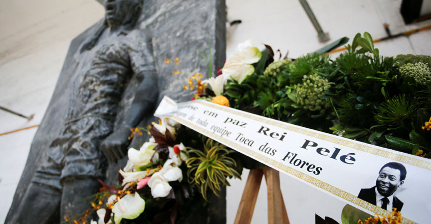Flowers are seen in front of a statue of Brazilian soccer legend Pele at the Vila Belmiro stadium on the eve of Pele's funeral in Santos, Brazil, January 1, 2023. REUTERS/Diego Vara

