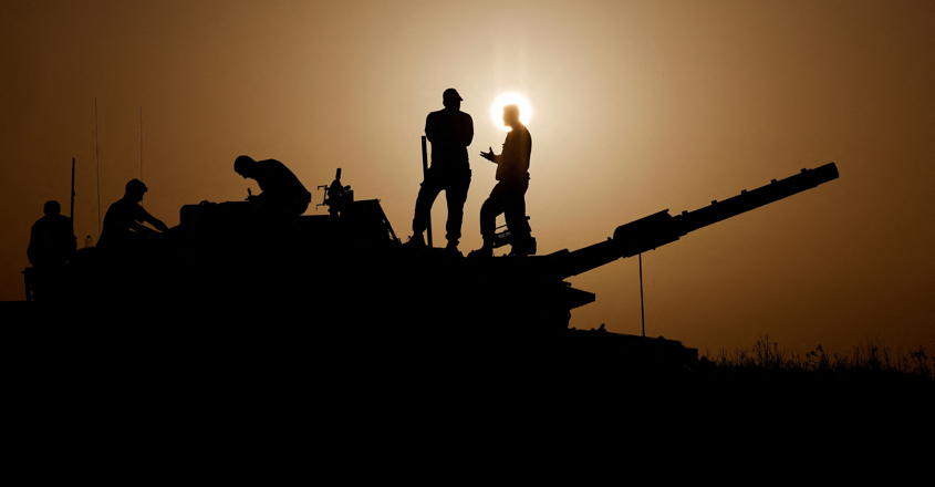 Israeli soldiers stand on a tank, amid the ongoing conflict between Israel and the Palestinian group Hamas, near Israel's border with Gaza in southern Israel, November 23, 2023. REUTERS/Amir Cohen
