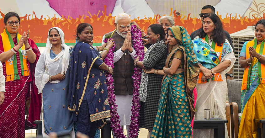 വനിതാ സംവരണ ബിൽ പാർലമെന്റ് പാസാക്കിയതിന്  പിന്നാലെ ബിജെപി ആസ്ഥാനത്ത്  പ്രധാനമന്ത്രി നരേന്ദ്ര മോദിയെ ആദരിക്കുന്നു (PTI Photo/Manvender Vashist Lav)