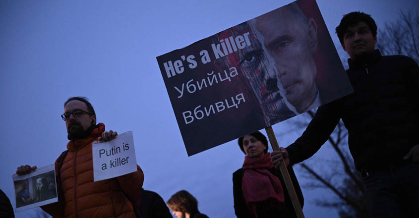 People hold signs outside the Russian Embassy in Washington, DC, on February 16, 2024, following the death of Russian opposition leader Alexei Navalny. Navalny died February 16 in the Arctic prison colony where he was serving a 19-year-term, Russia's federal penitentiary service said. (Photo by Brendan SMIALOWSKI / AFP)