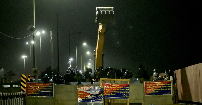 Police and Rapid Action Force (RAF) personnel in riot gear block a highway to prevent farmers from marching towards New Delhi during a protest demanding minimum crop prices, near the Haryana-Punjab state border in Shambhu at Patiala district about 200 kilometres (125 miles) north of the capital on February 21, 2024. Thousands of Indian farmers riding tractors prepared to resume their push towards New Delhi on February 21, terming it as "Delhi Chalo", or "March to Delhi", after failing to reach a deal with the government on their demands for higher crop prices. (Photo by Narinder NANU / AFP)