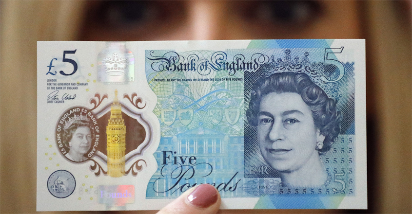 employee-shows-the-new-five-pound-note