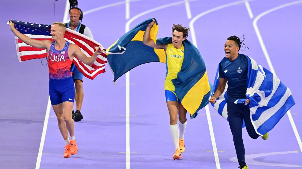 Winner Sweden's Armand Duplantis (C), second placed US' Sam Kendricks (L) and third placed Greece's Emmanouil Karalis celebrate after the men's pole vault final of the athletics event at the Paris 2024 Olympic Games at Stade de France in Saint-Denis, north of Paris, on August 5, 2024. (Photo by Martin  BERNETTI / AFP)