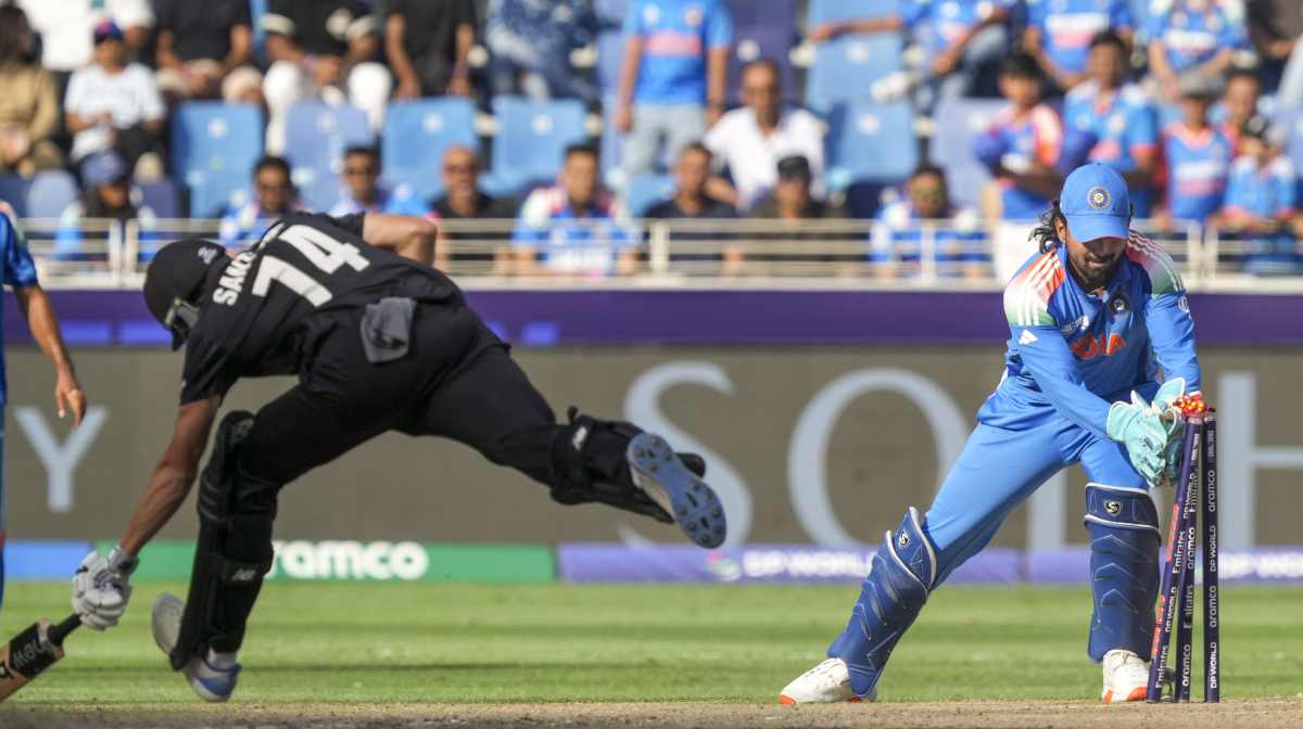India's wicketkeeper KL Rahul breaks the stumps to run-out New Zealand's captain Mitchel Santner during the ICC Champions Trophy final cricket match between India and New Zealand at Dubai International Cricket Stadium in Dubai, United Arab Emirates