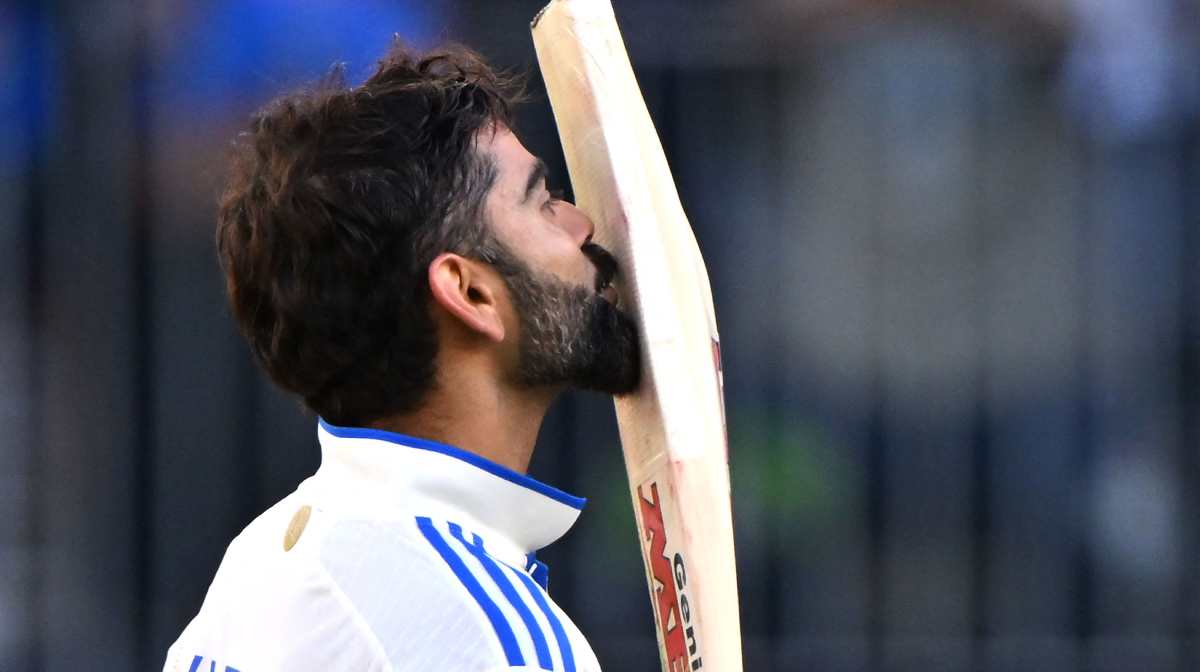 India s Virat Kohli kisses his bat as he celebrates reaching his century (100 runs) during day three of the first Test cricket match between Australia and India at Optus Stadium in Perth on November 24, 2024. (Photo by SAEED KHAN / AFP) / -- IMAGE RESTRICTED TO EDITORIAL USE - STRICTLY NO COMMERCIAL USE --