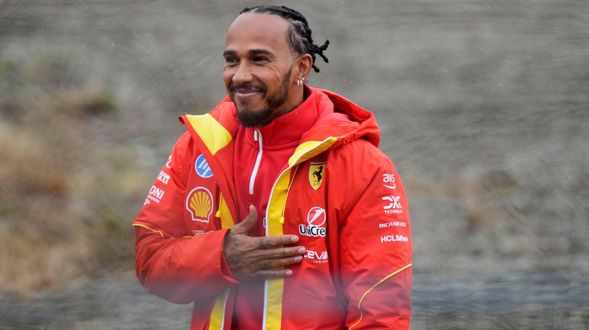 British driver Lewis Hamilton greets Ferrari fans gathered outside the track, after testing a Ferrari Formula One SF-23, in Fiorano Modenese, Italy, Wednesday, Jan.22, 2025. (AP Photo/Luca Bruno)
