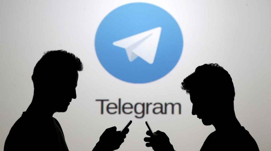 FILE PHOTO: Men pose with smartphones in front of a screen showing the Telegram logo in this picture illustration November 18, 2015. REUTERS/Dado Ruvic/File Photo